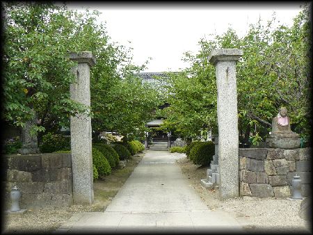 常光寺境内正面に設けられた石柱山門と石仏