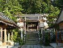 大山祇神社参道石畳み沿いにある手水舎と手水鉢、その奥に見える銅製鳥居
