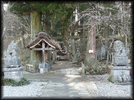 白河神社参道沿いに設けられた茅葺の手水舎と石造狛犬