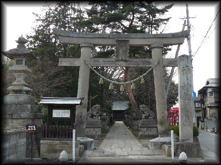 神炊館神社境内正面に設けられた大鳥居と常夜灯と石造社号標