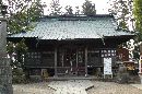 神炊館神社拝殿正面とその前に置かれた石造狛犬